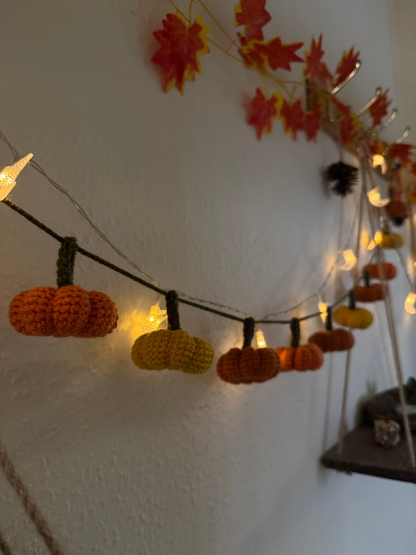 Beginners Friendly Crochet pumpkin garland pattern featuring handmade orange pumpkins with green stems on a rustic string, perfect for autumn, Halloween, and Thanksgiving decor
