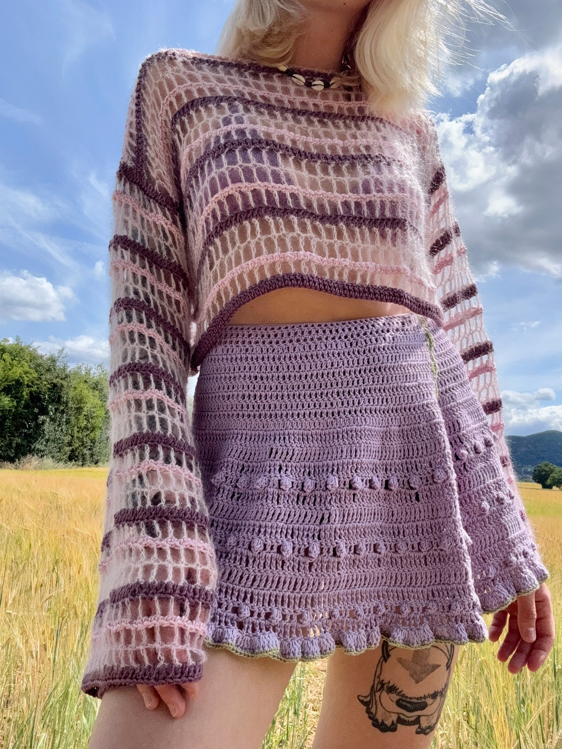 Summer crochet wrap skirt displayed outdoors from the front in purple color, lightweight for summer, customizable.