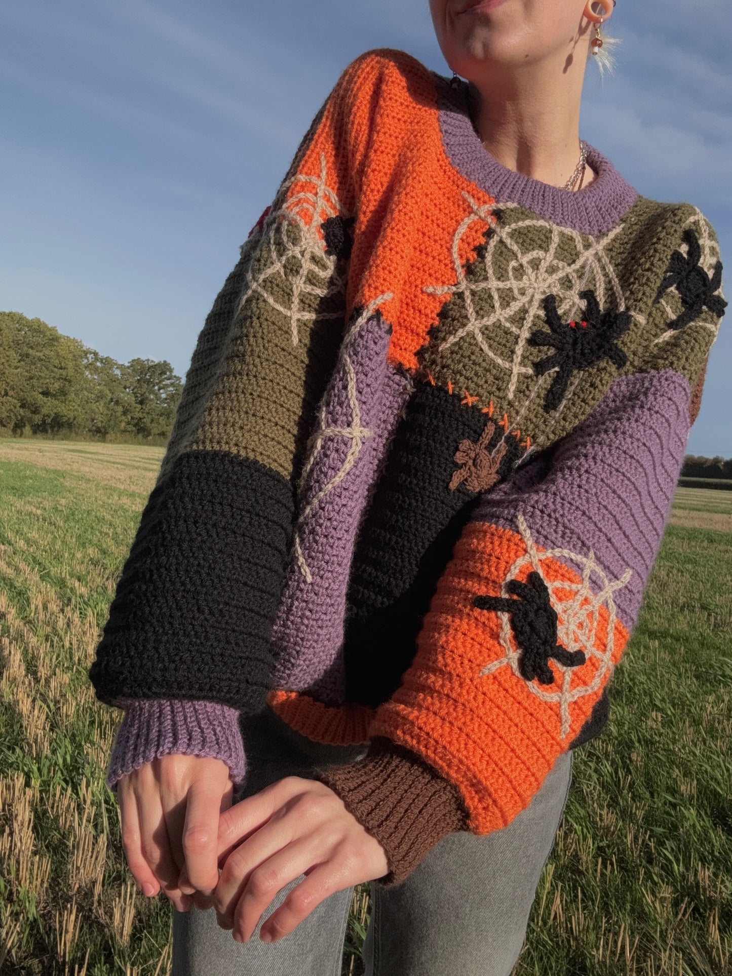 Beginners Friendly fall season oversized sweater crochet pattern, cozy fit for autumn weather. Sweater in green, brown, orange, purple colors.