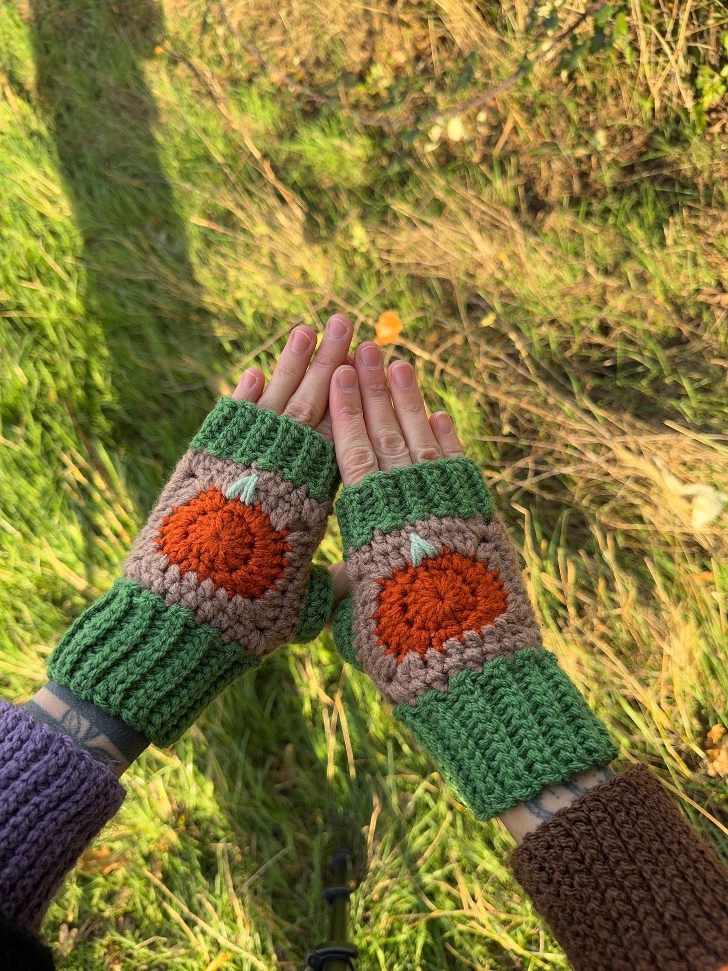 Handmade crochet fingerless gloves with pumpkin design for autumn, Thanksgiving gift. Gloves in orange, brown and green colors. Crochet pattern with step-by-step photo tutorials.