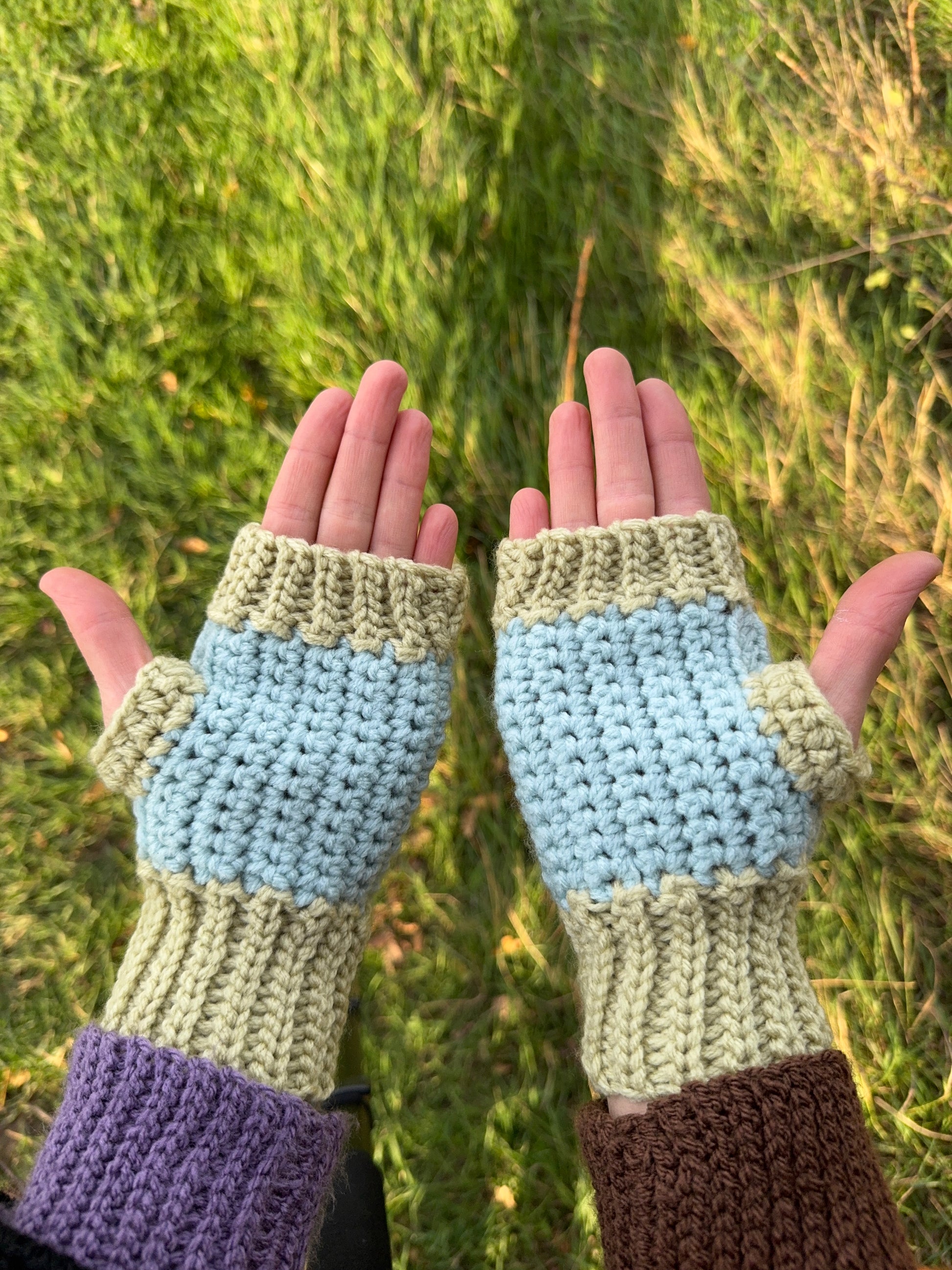 Autumn fingerless gloves crochet pattern – textured handmade wrist warmers in orange, green and brown colors. Easy beginner crochet project with a step-by-step photo tutorials. Picture shows the palm side of the glove.