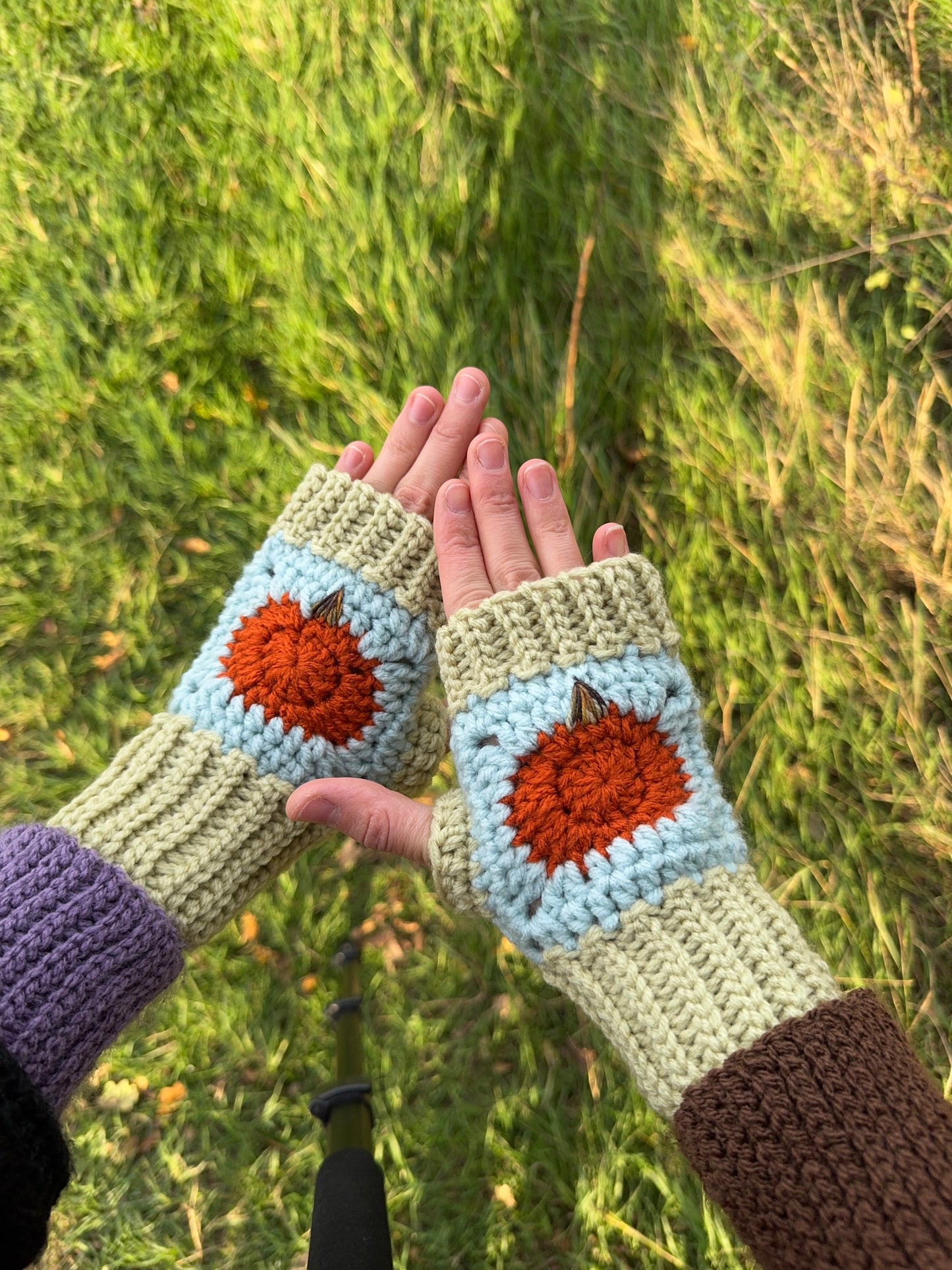Pumpkin fingerless gloves crochet pattern – textured handmade wrist warmers in orange, blue and green colors. Easy beginner crochet project with a step-by-step photo guide.