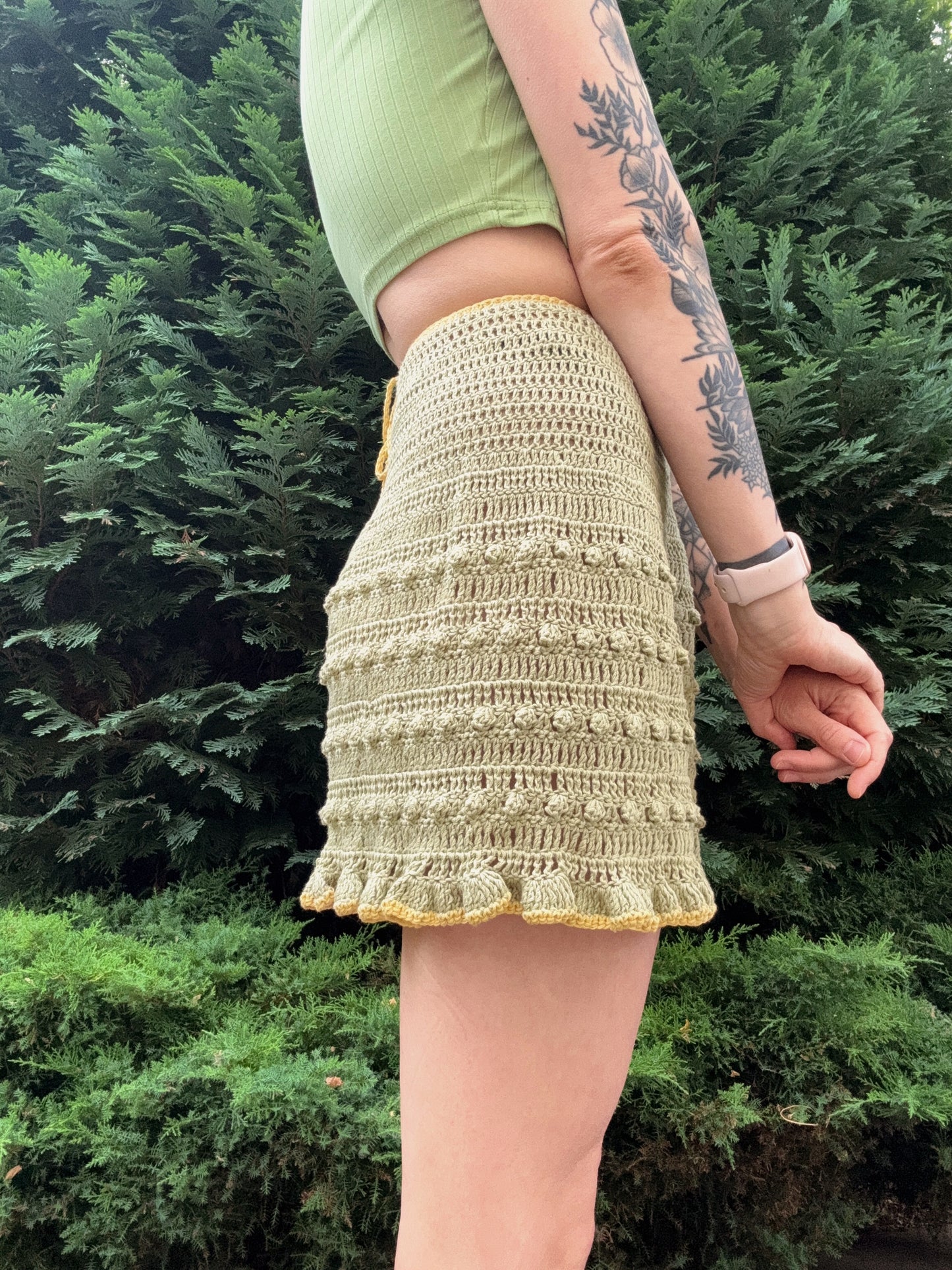 Lightweight crochet summer wrap skirt for women in green color from the side, customizable, beginner friendly crochet pattern.