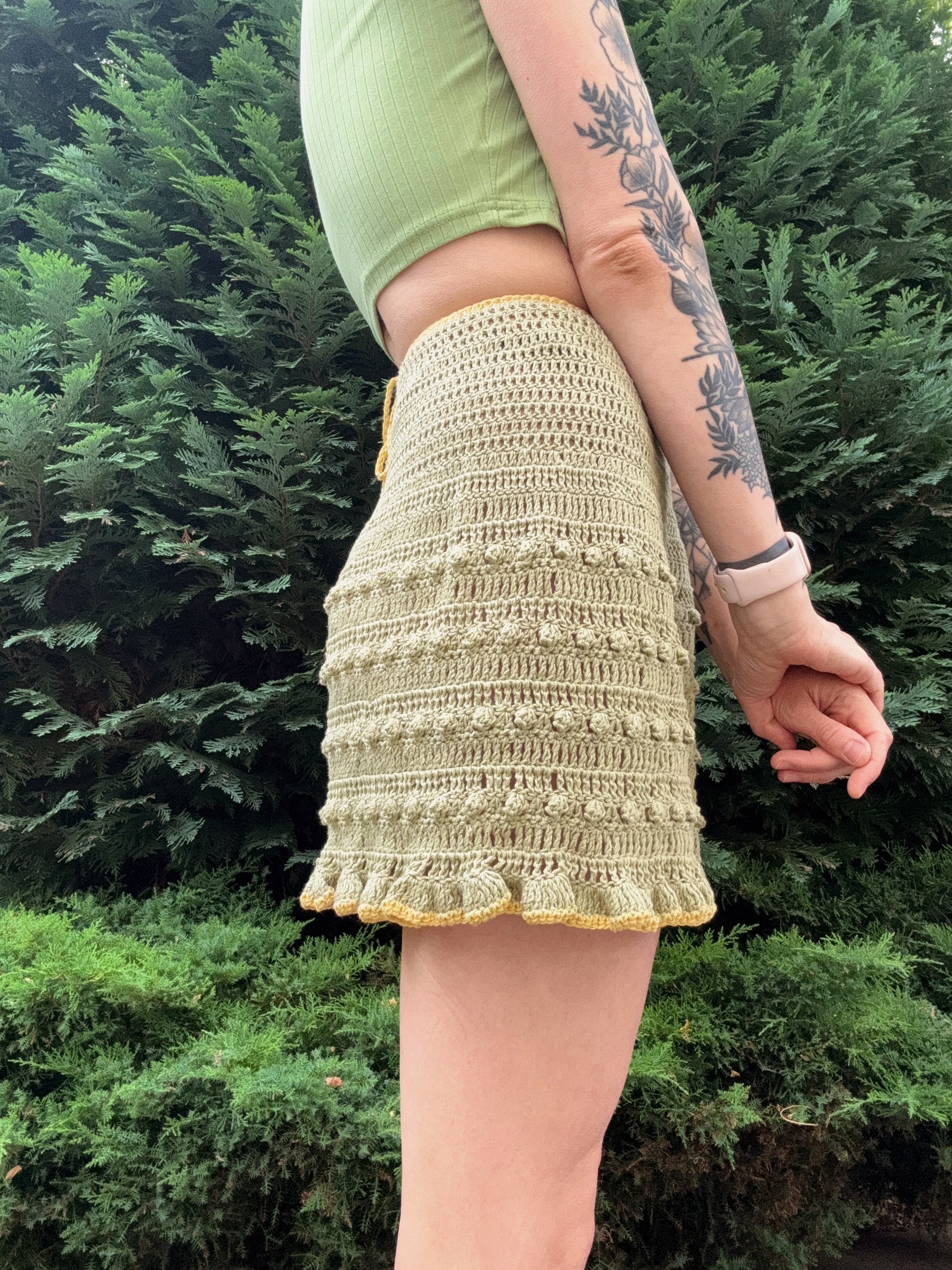 Lightweight crochet summer wrap skirt for women in green color from the side, customizable, beginner friendly crochet pattern.