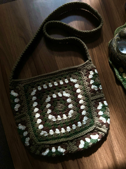 Crochet Pattern Of Granny Glam Bag Crochet Pattern with Grey, Dark Green Colour laying on the wooden desk.