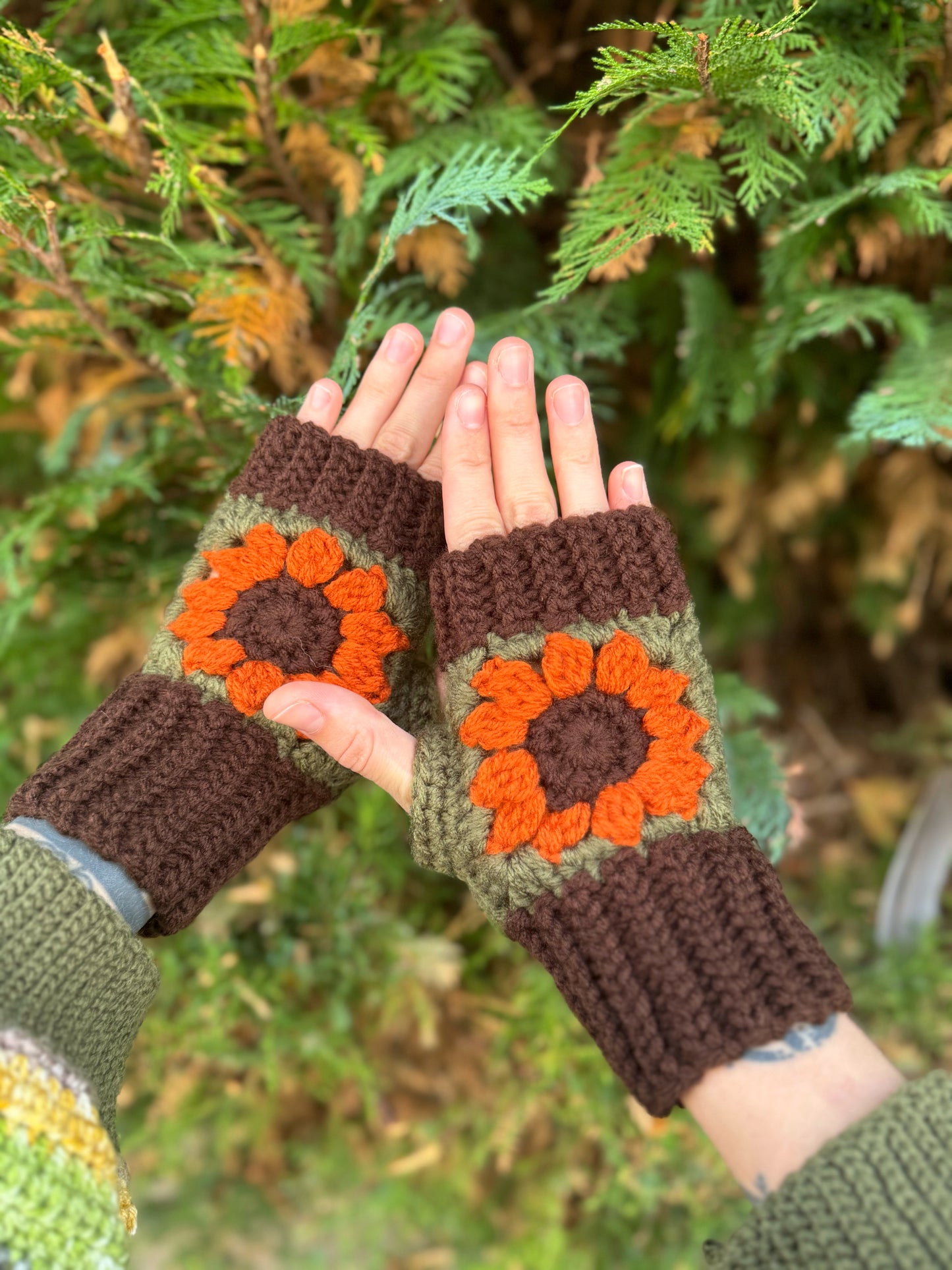 Fingerless gloves crochet pattern – textured handmade wrist warmers in brown, forest green and deep orange color. Easy beginner crochet project with a step-by-step photo tutorials.