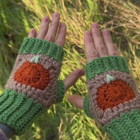 Autumn fingerless gloves crochet pattern – textured handmade wrist warmers in orange, green and brown colors. Easy beginner crochet project with a step-by-step photo tutorials. Picture shows the palm side of the glove.