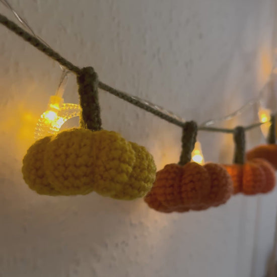 Beginners Friendly Crochet pumpkin garland pattern featuring handmade orange pumpkins with green stems on a rustic string, perfect for autumn, Halloween, and Thanksgiving decor