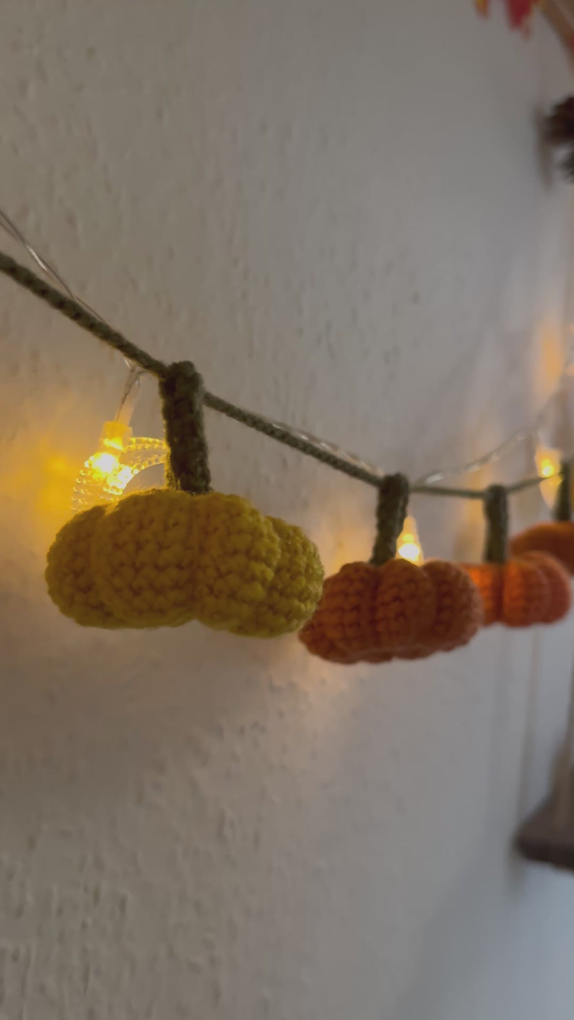 Beginners Friendly Crochet pumpkin garland pattern featuring handmade orange pumpkins with green stems on a rustic string, perfect for autumn, Halloween, and Thanksgiving decor