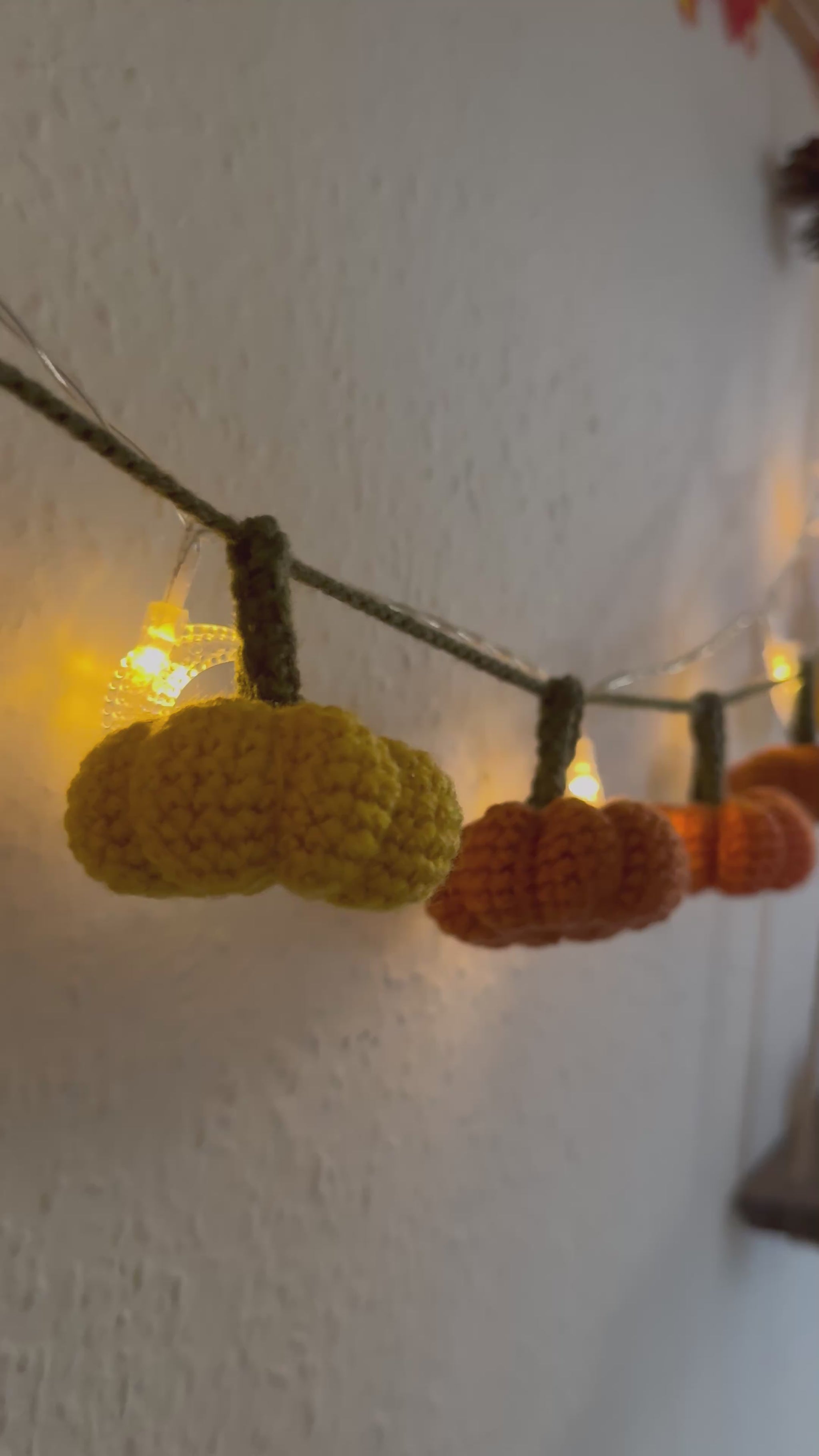 Beginners Friendly Crochet pumpkin garland pattern featuring handmade orange pumpkins with green stems on a rustic string, perfect for autumn, Halloween, and Thanksgiving decor